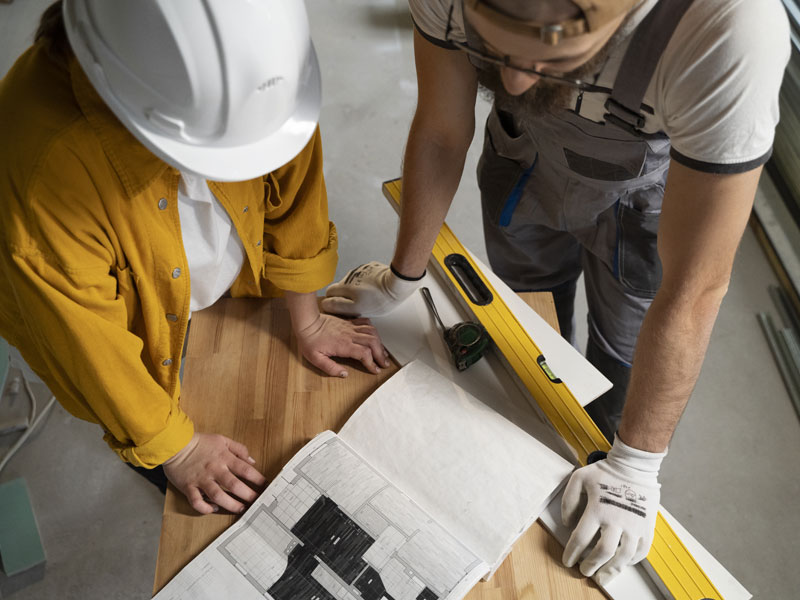 lavoratori discutono un progetto di costruzione in cantiere